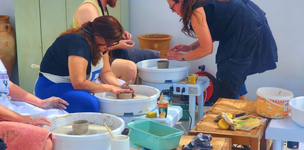 Guests learning pottery wheel techniques during a class on Golden Beach in Paros