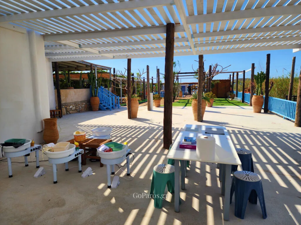Outdoor pottery workshop setup by the sea on Golden Beach in Paros