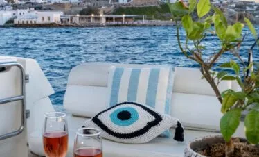 Aft deck drinks with Mykonos windmills view, private yacht cruise from Paros.