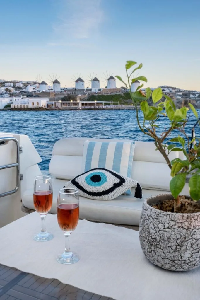 Aft deck drinks with Mykonos windmills view, private yacht cruise from Paros.