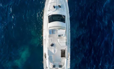 Top-down drone view of a Ferretti 46 yacht in blue water near Paros.
