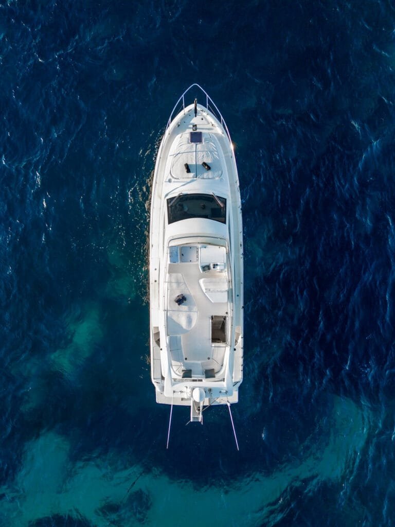 Top-down drone view of a Ferretti 46 yacht in blue water near Paros.