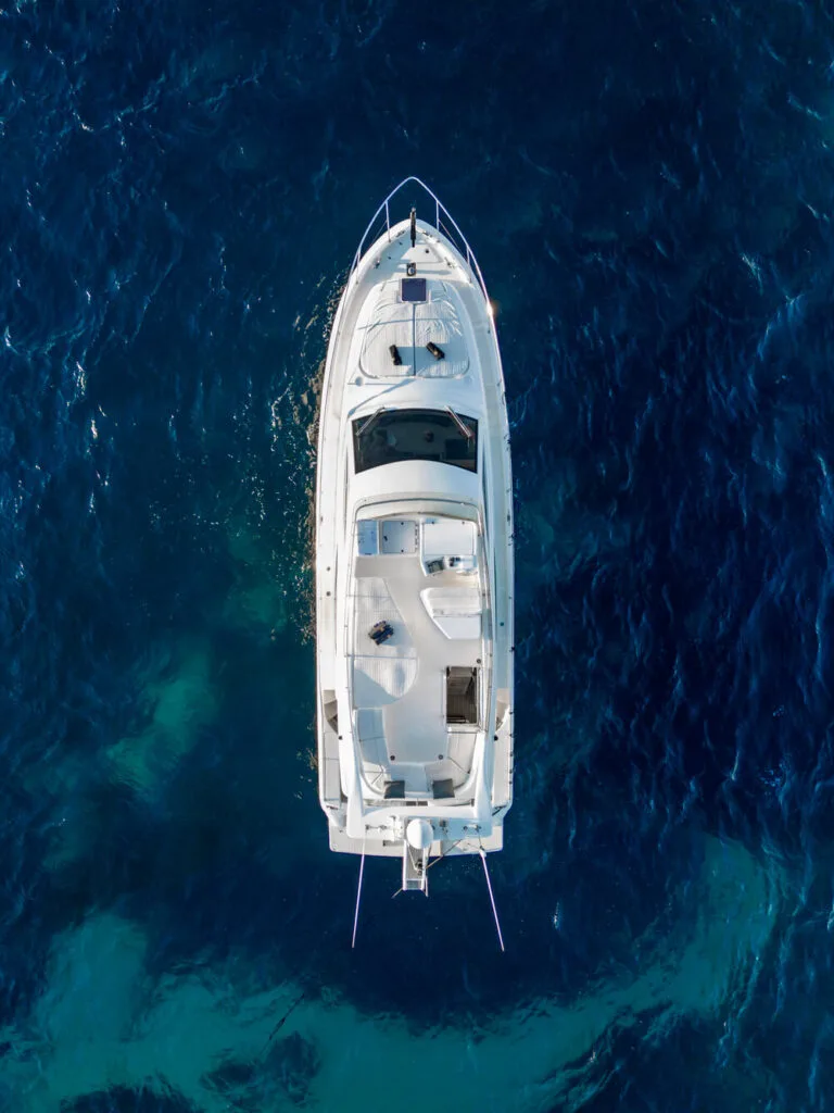 Top-down drone view of a Ferretti 46 yacht in blue water near Paros.
