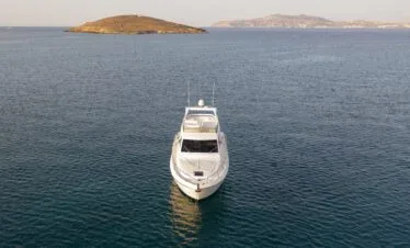 Front view of a Ferretti 46 on calm sea, private yacht cruise in Paros.